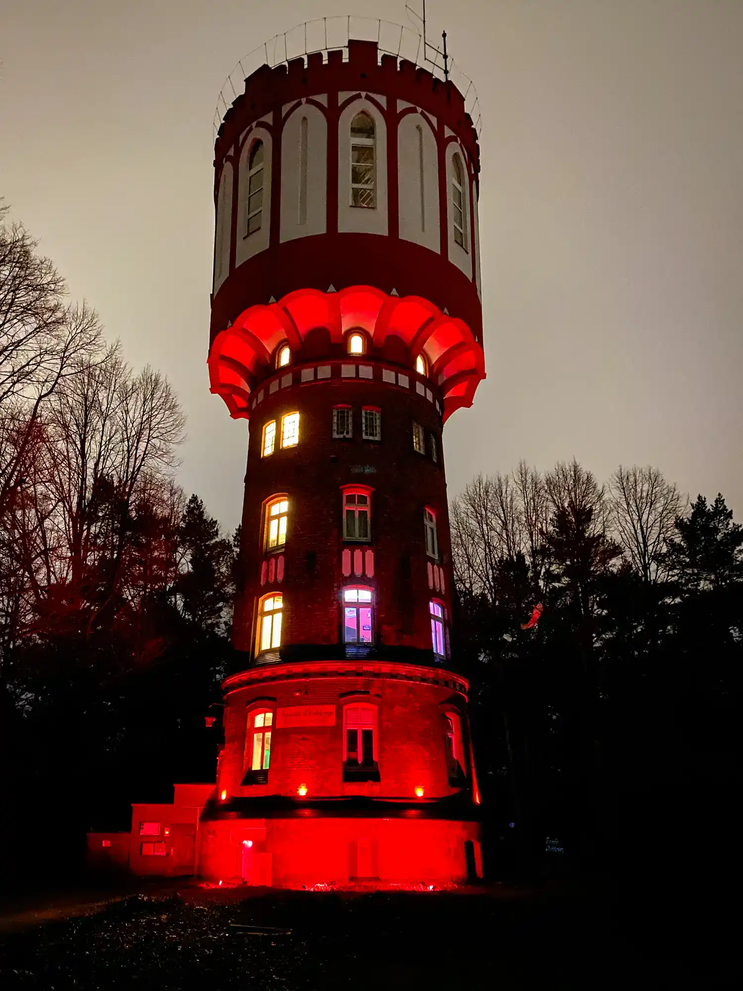 Alter Turm in Detmold bei Nacht, beleuchtet mit bunten Lichtern, schafft eine eindrucksvolle und historische Atmosphäre, ideal für Fotografie und Sightseeing.